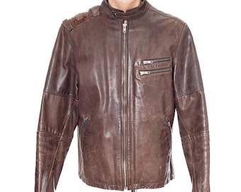 May include: A brown leather jacket featuring a stand-up collar with a snap button closure, a full-length front zipper, two horizontal zippered chest pockets, and two lower zippered pockets. The shoulders include decorative stitched leather panels.