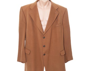May include: A tan blazer with a notched lapel, three-button closure, and two front pockets. The jacket is displayed on a mannequin against a white background. The blazer has a classic, tailored design.
