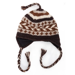 Puede incluir: Un gorro de punto marrón, blanco y beige con orejeras y una borla trenzada. El gorro presenta un patrón geométrico y una parte superior trenzada. Las orejeras tienen lazos trenzados. El gorro está diseñado para el clima frío.