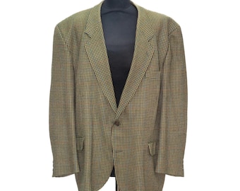 May include: A green, brown, and blue plaid blazer displayed on a black mannequin. The blazer has a notched lapel, two front pockets, and a single-button closure. The fabric has a textured appearance.