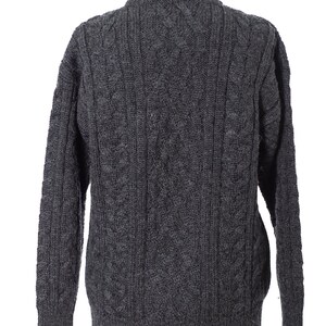 May include: A dark gray cable-knit sweater with a crew neck. The back of the sweater is displayed, showcasing the intricate knit pattern. The sleeves are long, and the sweater appears to be made of a thick, warm material.