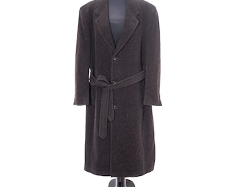 May include: A dark brown, long wool coat with a belted waist and notched lapels. The coat is displayed on a black mannequin and has a classic, tailored design. The coat is a full-length style.