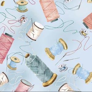 May include: A light blue background features a pattern of spools of thread, needles, and loose threads in various colors. The spools are in shades of pink, blue, and cream, with wooden or gold-colored bases. The needles are silver.