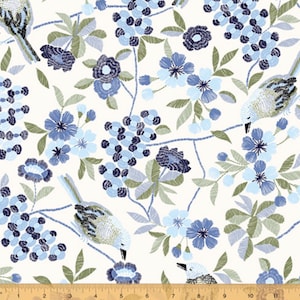 May include: White fabric with a repeating pattern of blue and green birds, flowers, and leaves. The pattern is embroidered.