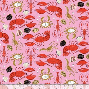 May include: Pink fabric with a repeating pattern of red lobsters, gold crabs, and seashells. The design includes black and white accents and small white bubbles. A nautical theme.