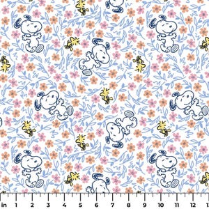 May include: White fabric featuring a repeating pattern of Snoopy in blue outline, yellow Woodstock, pink and peach flowers, and blue leaves. The design is whimsical and suitable for various craft projects.