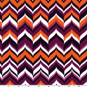 May include: Orange, purple, white, and black chevron pattern fabric. The fabric has a repeating pattern of pointed shapes.