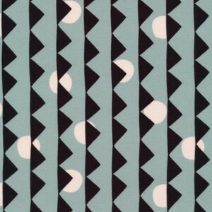 Könnte beinhalten: Ein blaugrüner Stoff mit einem sich wiederholenden Muster aus schwarzen Dreiecken und weißen Kreisen.