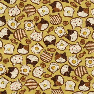 May include: A yellow fabric with a repeating pattern of cats, toast, and eggs. The cats are drawn in a cartoon style with black and white fur. The toast is brown and has a variety of toppings, including butter, jam, and eggs. The eggs are white and have a yellow yolk.