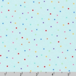 May include: A light blue fabric with a scattered pattern of colorful stars. The stars are in various shades of red, orange, yellow, green, blue, and purple.