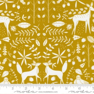 May include: A mustard yellow fabric with a white repeating pattern of stylized deer, foxes, owls, leaves, and acorns. The fabric is measured with a ruler in inches.
