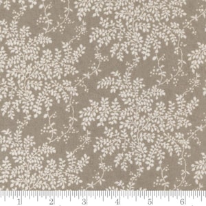 Op de afbeelding: Taupe stof met een herhaald patroon van witte bladerranken. Het ontwerp toont gedetailleerde bladeren en stelen, wat een natuurlijke uitstraling creëert. Geschikt voor quilt- en naaiprojecten. Zacht kleurenpalet.