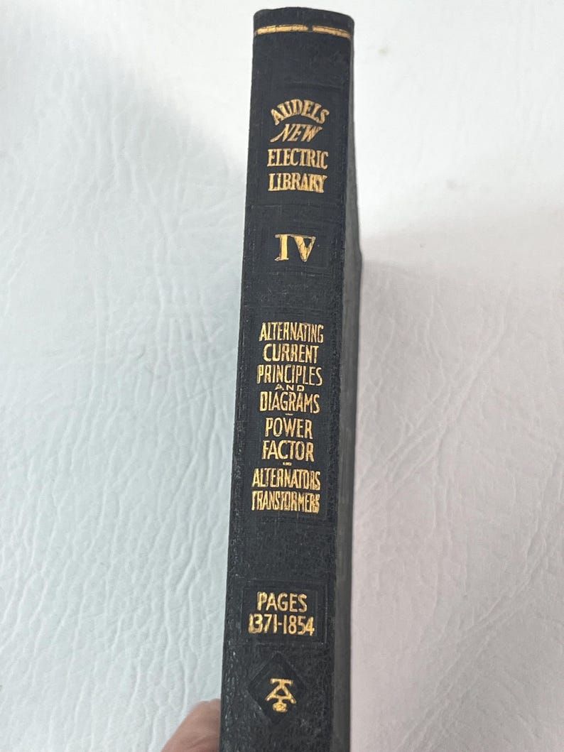 Puede incluir: Un libro negro con letras doradas, titulado "Audels New Electric Library, Volumen IV." El lomo detalla "Alternating Current Principles", "Diagrams" y "Transformers". Las p&aacute;ginas est&aacute;n numeradas de 1371 a 1854.