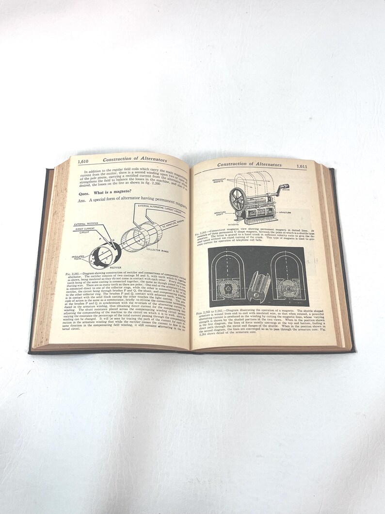 Puede incluir: Un libro abierto con cubiertas negras, que muestra diagramas y texto sobre la construcci&oacute;n de alternadores. Las p&aacute;ginas est&aacute;n amarillentas, con t&eacute;rminos t&eacute;cnicos e ilustraciones de componentes mec&aacute;nicos.