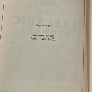 Puede incluir: P&aacute;ginas abiertas de un libro con texto de "Audel's New Electric Library". El texto incluye "Reprinted 1943" y "Copyrighted 1929, 1940 Theo. Audel & Co." Las p&aacute;ginas est&aacute;n envejecidas con un color beige claro.