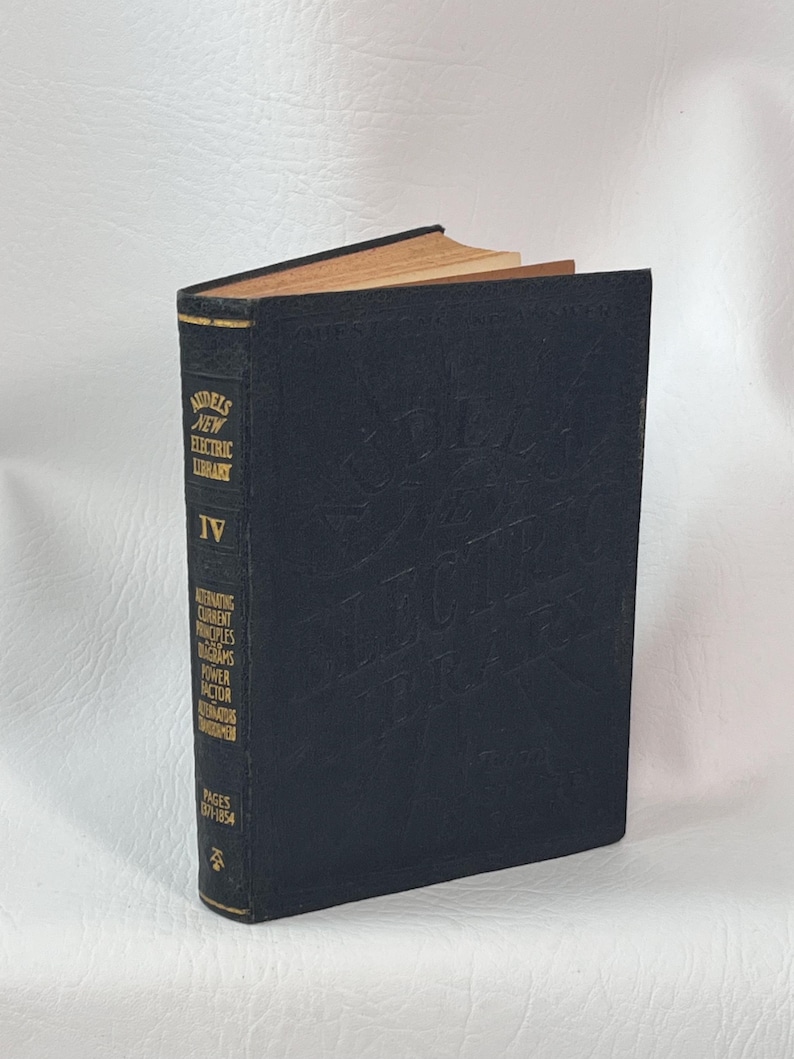 Puede incluir: Un libro antiguo de tapa dura negra, titulado "Audel's New Electric Library IV". El t&iacute;tulo est&aacute; en letras doradas y en relieve. El lomo del libro detalla temas como la corriente alterna y los diagramas. Las p&aacute;ginas est&aacute;n amarillentas.