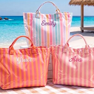 Peut inclure: Trois sacs fourre-tout rectangulaires avec deux poignées supérieures, chacun présentant des rayures verticales et un prénom brodé sur le devant. Le sac arrière a des rayures pastel avec le nom Emily, tandis que les sacs avant ont des rayures orange et rose.
