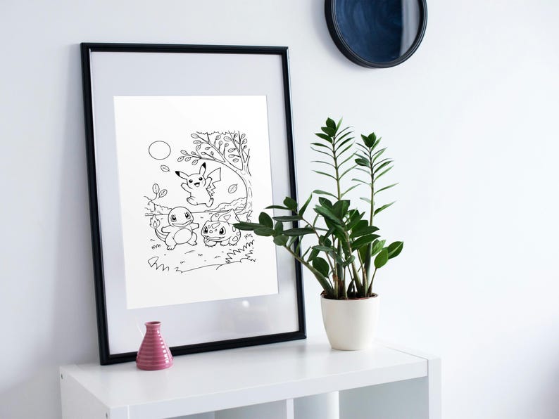 May include: Black and white framed print featuring a cartoon illustration of Pikachu, Charmander, and Bulbasaur in a forest setting. The artwork is displayed on a white shelf with a pink vase and a potted plant.
