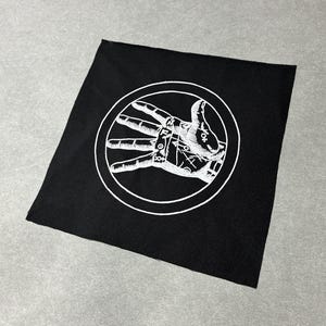 May include: Black square patch featuring a white hand illustration within a circle. The hand shows the palm and fingers with detailed lines and symbols. The patch is made of fabric.