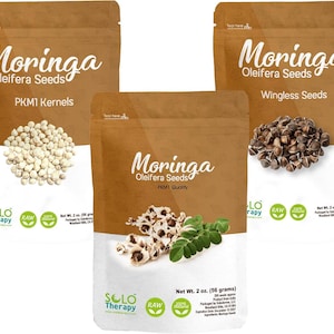 May include: Three brown paper bags of Moringa Oleifera Seeds. The bags have the text "Moringa Oleifera Seeds" in white. One bag says "PKM1 Kernels" and displays white seeds. Another says "Wingless Seeds" and displays brown seeds. The third bag says "PKM1 Quality" and displays white seeds and green leaves.