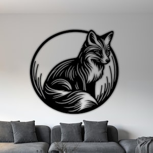 May include: Black metal fox wall art. The fox is depicted in a sitting position within a circular frame. The artwork is mounted on a white wall above a gray sofa. The fox has detailed fur and a focused gaze.
