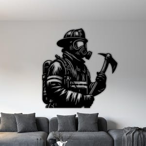 May include: Black metal wall art depicting a firefighter in full gear, including a helmet, gas mask, and oxygen tank. The firefighter is holding a fire axe. The artwork is mounted on a white wall above a gray sofa.