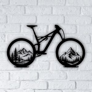 Puede incluir: Arte de pared de bicicleta de montaña de metal negro. La silueta de la bicicleta presenta escenas de montañas y bosques dentro de las ruedas. La obra de arte está montada en una pared de ladrillos blancos.