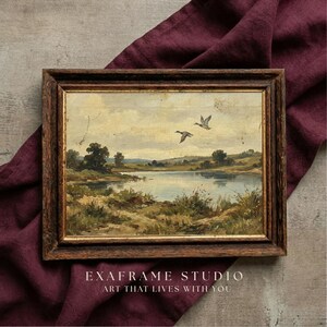 [Mallard Ducks Antique Oil Painting] shown in a detailed close-up within a textured dark wood frame resting on a luxurious Plum Noir fabric backdrop. This mockup highlights the authentic soul of the flying birds and the aged patina of the vintage wetland landscape. The lighting emphasizes the fine art canvas texture and painterly details, making it a perfect gift for nature lovers and vintage collectors — see every detail and download instantly.