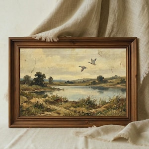 [Antique Style Art] showing the flying ducks print in a deep brown wooden frame with a piece of natural linen fabric draped over the corner. The soft lighting emphasizes the muted colors and vintage patina of the lake landscape painting. This detailed mockup highlights the "Modern Heritage" vibe of the artwork, showing how it fits into a rustic farmhouse aesthetic — bring warmth home with high-quality 300 DPI digital art download.