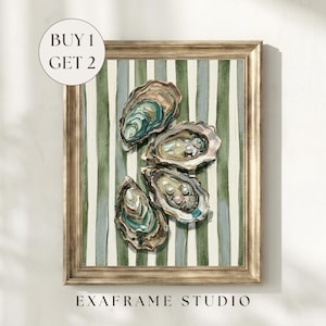 May include: A framed wall art print featuring four oyster shells arranged on a background of vertical green and white stripes. Two of the oyster shells contain small white pearls. The frame is metallic gold with a textured finish.
