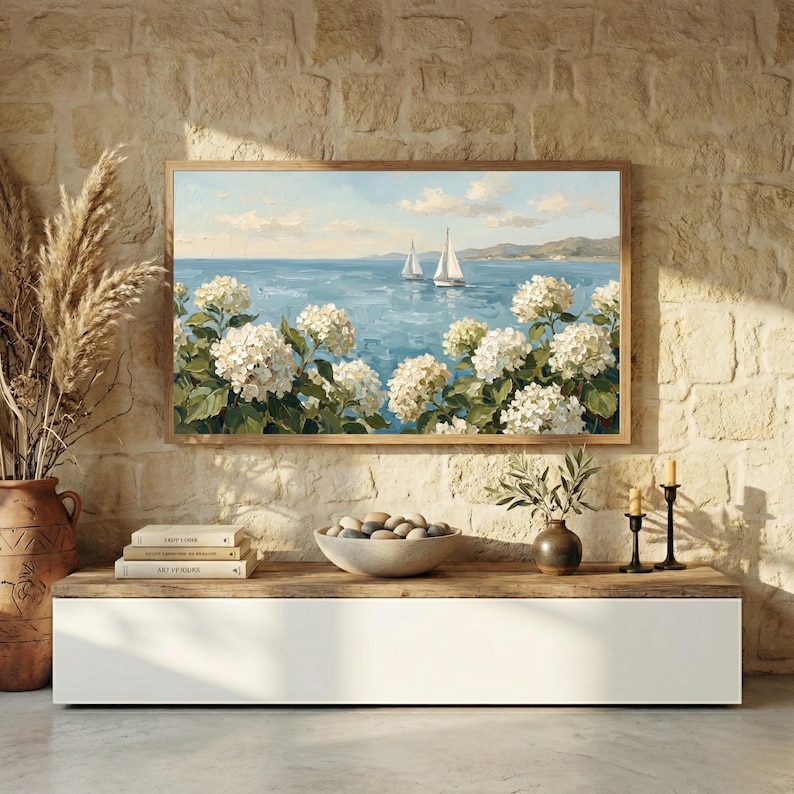 A sleek coastal noir-inspired living space with a white floating console and a rustic stone accent wall. The vibrant sailboats and lush white flowers on the TV screen provide a soft, organic contrast to the architectural lines of the room. This setup highlights the human premium feel of the oil painting's visible brushstrokes against modern technology. Give your smart TV a high-end makeover with this coastal art—get your files instantly.
