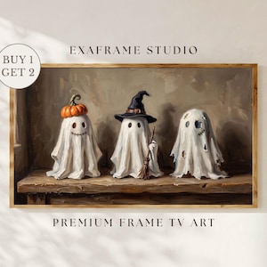 May include: A framed digital art print titled EXAFRAME STUDIO PREMIUM FRAME TV ART featuring three white ghost figures on a wooden shelf. The first ghost wears a pumpkin, the second a witch hat with a broom, and the third has tattered holes.