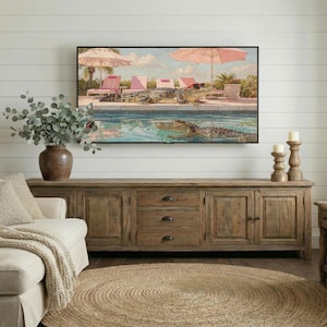 A cozy farmhouse interior showing a large wooden credenza and a woven jute rug. The Samsung Frame TV displays the quirky Palm Springs crocodile art, creating a brilliant focal point against the white paneled wall. The painting’s summer colors and retro vibe bring a fresh energy to the traditional rustic furniture. Perfect for anyone looking to add a touch of personality to their farmhouse decor. Get this instant digital download today.