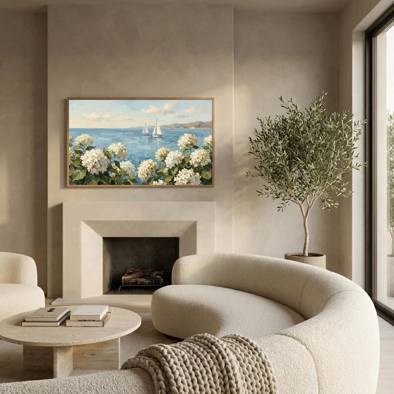 A luxurious living room scene with a contemporary curved sofa and a classic fireplace. Above the mantel, the Samsung Frame TV displays the serene Nantucket seaside painting, acting as a high-end statement piece. The soft lighting and high-quality textures in the room emphasize the old money decor vibe of the sailboats and hydrangeas. Transform your television into a portal to the ocean—purchase this digital masterpiece and save today.