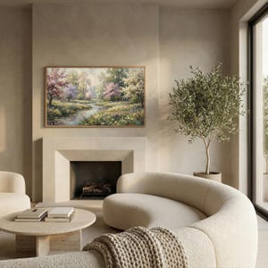 Modern neutral living room mockup featuring a curved beige sofa and olive tree. The Samsung Frame TV displays a romantic spring oil painting with blooming trees and a river. Demonstrates how vintage art complements modern heritage and warm minimalist interiors. Creates a calm and sophisticated atmosphere. Shop this elegant digital decor for your home.