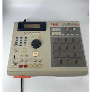 May include: An Akai Professional MPC2000XL MIDI Production Centre in a beige casing. The device features a central black data wheel, a grid of sixteen square grey drum pads, a rectangular LCD screen, various control buttons, and a slider.