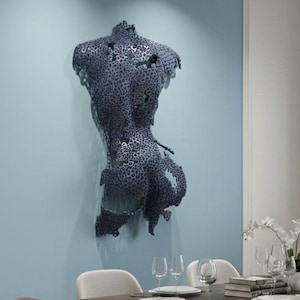 May include: A modern dining room featuring a dark wood table with six upholstered chairs. A metal sculpture of a torso hangs on a light blue wall. The room is illuminated by a track lighting system.