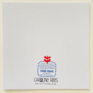 May include: A white card with a blue and red sticker that says "I recommend presenting your paper cut in a box frame which prevents the glass from pressing against the paper. HAND MADE IN WALES GWNAED YNG NGHYMRU CAROLINE REES www.carolinerees.co.uk"