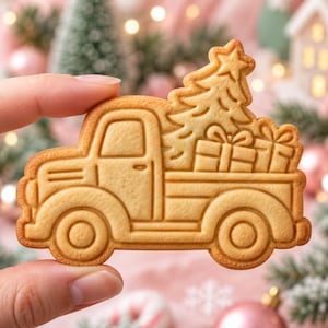 Puede incluir: Una galleta de color marrón claro con forma de camión que presenta un diseño en relieve de un árbol de Navidad y dos cajas de regalo en la parte trasera. La galleta tiene una textura horneada suave con contornos definidos del vehículo.