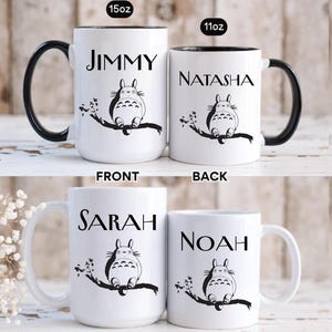 May include: White ceramic mugs with black accents and handles. Each mug features a name and a black and white illustration of a cartoon character sitting on a branch. The mugs are available in 15oz and 11oz sizes.