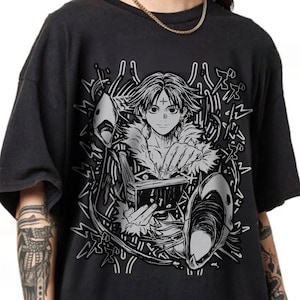 May include: Dark gray t-shirt featuring a black and white anime-style illustration. The graphic depicts a character holding a book, with stylized elements and text accents. The design includes a cross on the character's forehead and mask details.