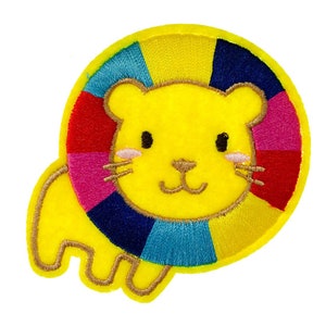 May include: A yellow felt lion applique with a colourful rainbow mane. The lion has a smiling face with black eyes and a pink nose.