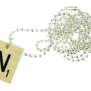 May include: A wooden Scrabble tile necklace with the letter "N" and the number "1" on it. The necklace is made of a silver chain.