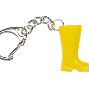 Peut inclure: Un porte-clés en forme de botte en caoutchouc jaune avec une chaîne et un fermoir en métal argenté.