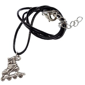 May include: A black leather necklace with a silver roller skate charm. The necklace has a lobster clasp and a silver chain extension.