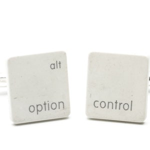 May include: A pair of white cufflinks shaped like computer keys. The left cufflink says "alt option" and the right cufflink says "control".