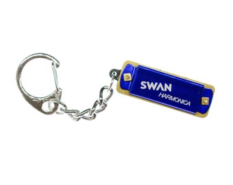 May include: A blue and gold keychain harmonica with the text "SWAN HARMONICA" on the front.