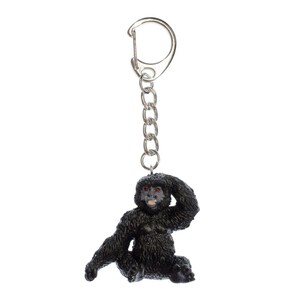 May include: A black gorilla keychain with a silver chain and a silver ring. The gorilla is sitting with its hand on its head.
