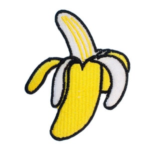 Peut inclure: Une banane brodée jaune avec un contour noir et une pelure blanche. La banane est pelée et l'intérieur est visible.