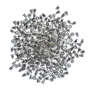 May include: A large pile of silver-toned earring backs. The backs are small and round with a post sticking out of the top.